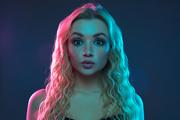 Image showing Caucasian young woman\'s portrait on gradient background in neon light