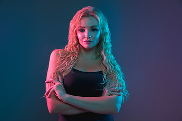 Image showing Caucasian young woman\'s portrait on gradient background in neon light