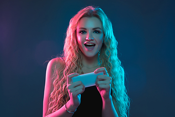 Image showing Caucasian young woman\'s portrait on gradient background in neon light