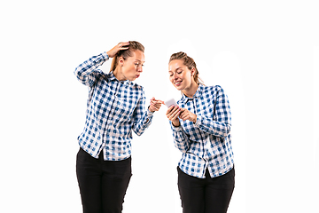 Image showing Young handsome woman arguing with herself on white studio background.