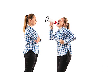 Image showing Young handsome woman arguing with herself on white studio background.