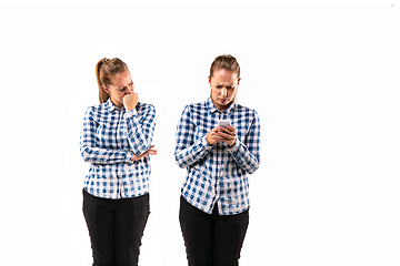 Image showing Young handsome woman arguing with herself on white studio background.