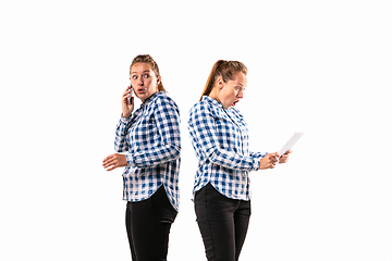 Image showing Young handsome woman arguing with herself on white studio background.