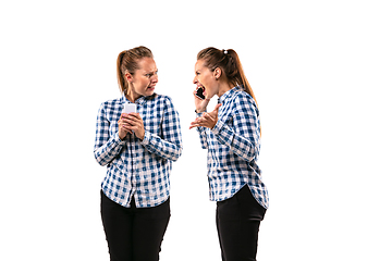 Image showing Young handsome woman arguing with herself on white studio background.