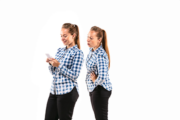 Image showing Young handsome woman arguing with herself on white studio background.