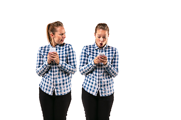 Image showing Young handsome woman arguing with herself on white studio background.