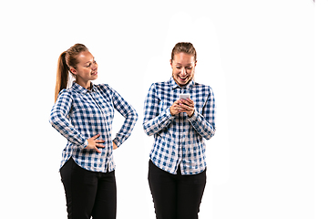 Image showing Young handsome woman arguing with herself on white studio background.