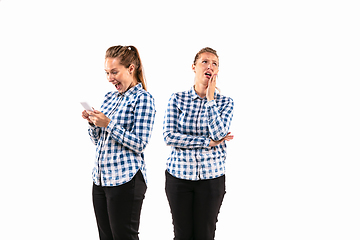 Image showing Young handsome woman arguing with herself on white studio background.