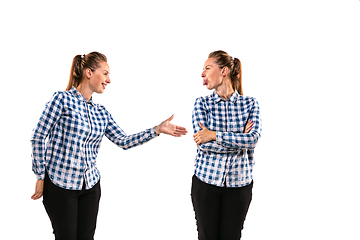 Image showing Young handsome woman arguing with herself on white studio background.