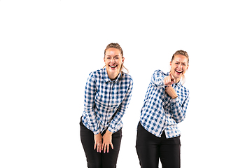 Image showing Young handsome woman arguing with herself on white studio background.