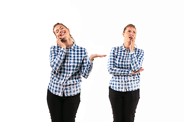 Image showing Young handsome woman arguing with herself on white studio background.