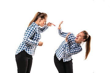 Image showing Young handsome woman arguing with herself on white studio background.