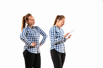 Image showing Young handsome woman arguing with herself on white studio background.