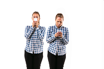 Image showing Young handsome woman arguing with herself on white studio background.