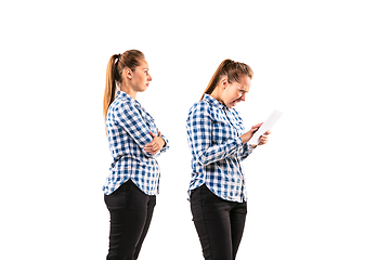 Image showing Young handsome woman arguing with herself on white studio background.