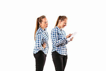 Image showing Young handsome woman arguing with herself on white studio background.