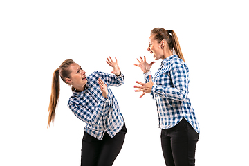 Image showing Young handsome woman arguing with herself on white studio background.