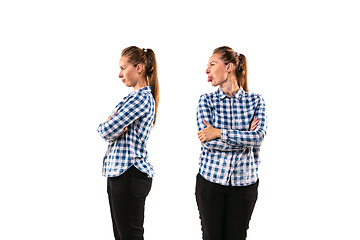 Image showing Young handsome woman arguing with herself on white studio background.