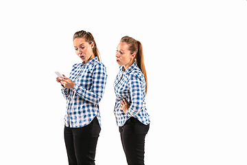 Image showing Young handsome woman arguing with herself on white studio background.