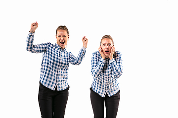 Image showing Young handsome woman arguing with herself on white studio background.