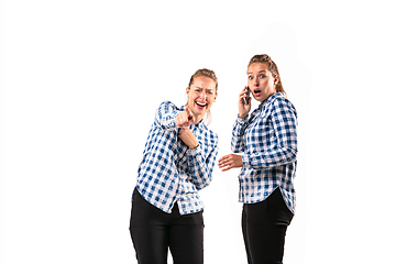 Image showing Young handsome woman arguing with herself on white studio background.