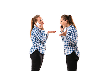 Image showing Young handsome woman arguing with herself on white studio background.