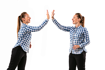 Image showing Young handsome woman arguing with herself on white studio background.