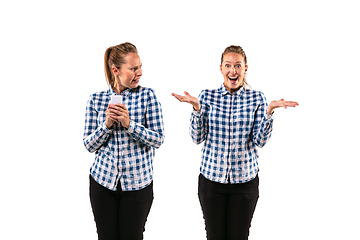 Image showing Young handsome woman arguing with herself on white studio background.