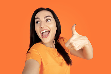 Image showing Caucasian young woman\'s portrait on orange background