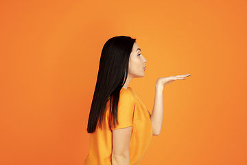 Image showing Caucasian young woman\'s portrait on orange background