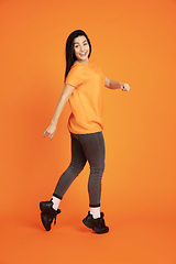 Image showing Caucasian young woman\'s portrait on orange background