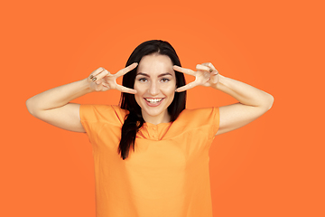 Image showing Caucasian young woman\'s portrait on orange background