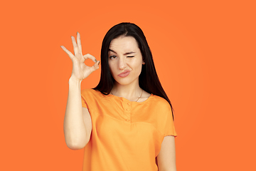 Image showing Caucasian young woman\'s portrait on orange background