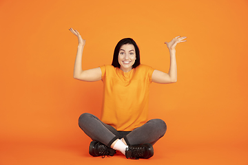 Image showing Caucasian young woman\'s portrait on orange background