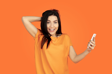 Image showing Caucasian young woman\'s portrait on orange background