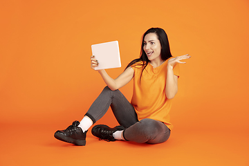 Image showing Caucasian young woman\'s portrait on orange background