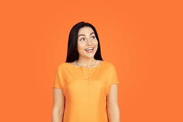 Image showing Caucasian young woman\'s portrait on orange background