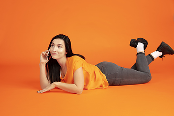 Image showing Caucasian young woman\'s portrait on orange background