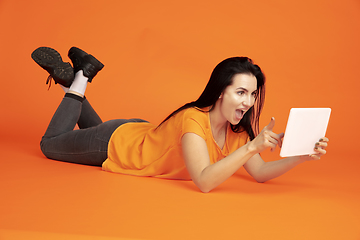 Image showing Caucasian young woman\'s portrait on orange background