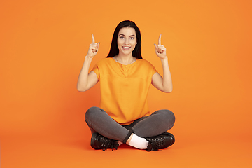 Image showing Caucasian young woman\'s portrait on orange background