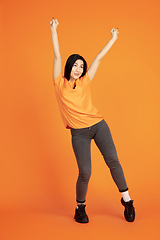 Image showing Caucasian young woman\'s portrait on orange background