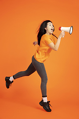 Image showing Caucasian young woman\'s portrait on orange background