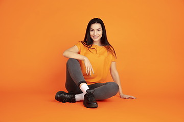 Image showing Caucasian young woman\'s portrait on orange background