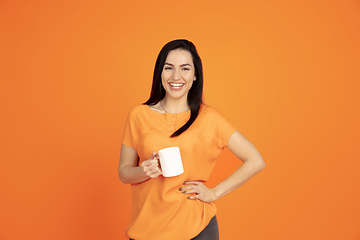 Image showing Caucasian young woman\'s portrait on orange background