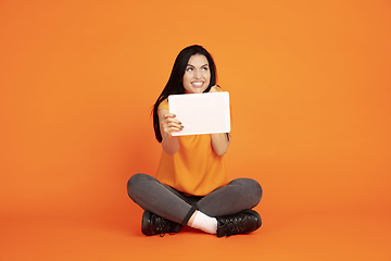 Image showing Caucasian young woman\'s portrait on orange background