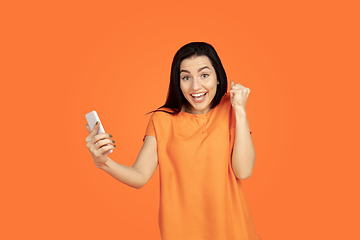 Image showing Caucasian young woman\'s portrait on orange background