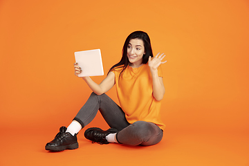 Image showing Caucasian young woman\'s portrait on orange background