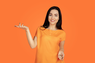 Image showing Caucasian young woman\'s portrait on orange background