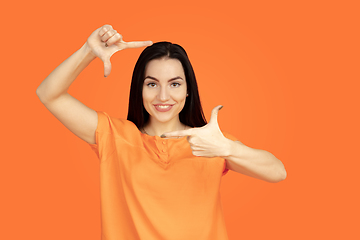 Image showing Caucasian young woman\'s portrait on orange background