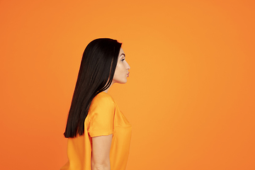 Image showing Caucasian young woman\'s portrait on orange background